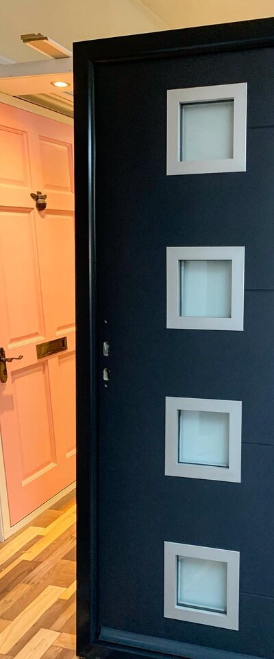 An anthracite contemporary composite door with four square glazed lights in the showroom