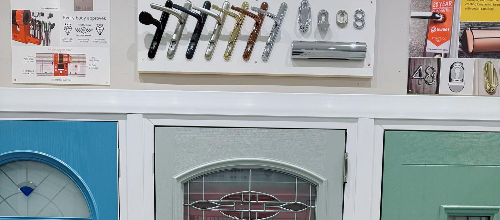 The handle and escutcheon display board above three composite door heads on the showroom wall