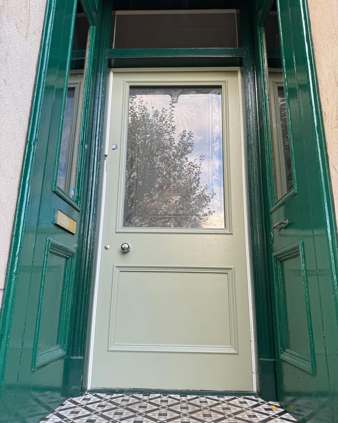 A sandstone entry: green storm doors folded back and the new sage door made to take the customer’s antique acid-etched glass