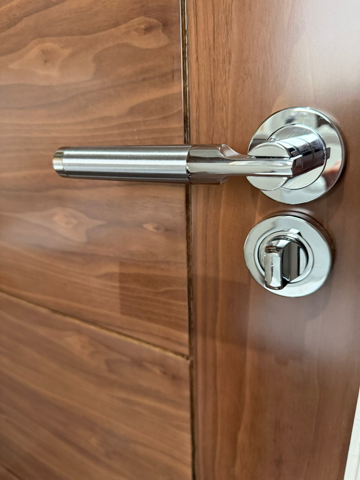 Walnut grain with a polished chrome lever and thumb-turn