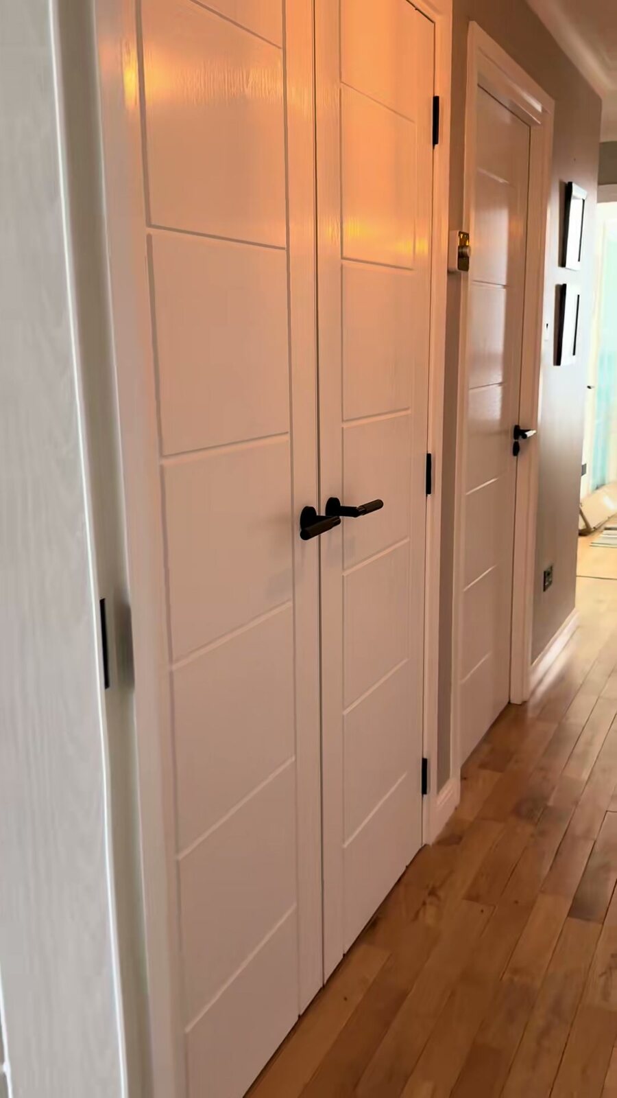 A pair of white grooved panel doors on an oak floor
