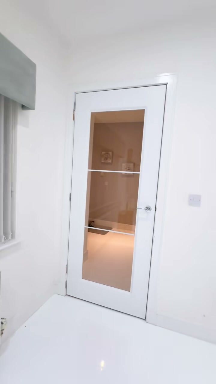 A white urban glazed door in an all-white hall